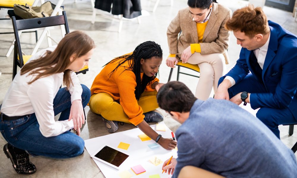 Project managers and employees brainstorming on ideas - Multi-ethnic group of workers having business meeting in a start-up office