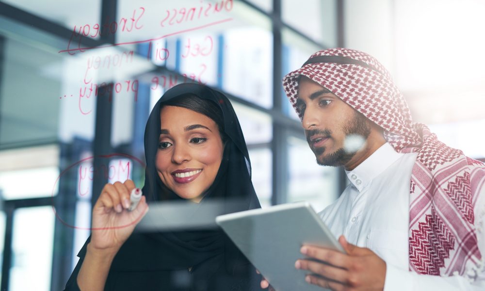 Shot of two muslim colleagues having a brainstorming session at work in a modern office.